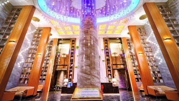 Una biblioteca amb una columna central, prestatges de llibres i zones d'seure.