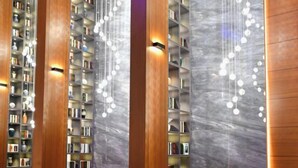 Una biblioteca amb altes prestatgeries i llums esfèriques penjants.