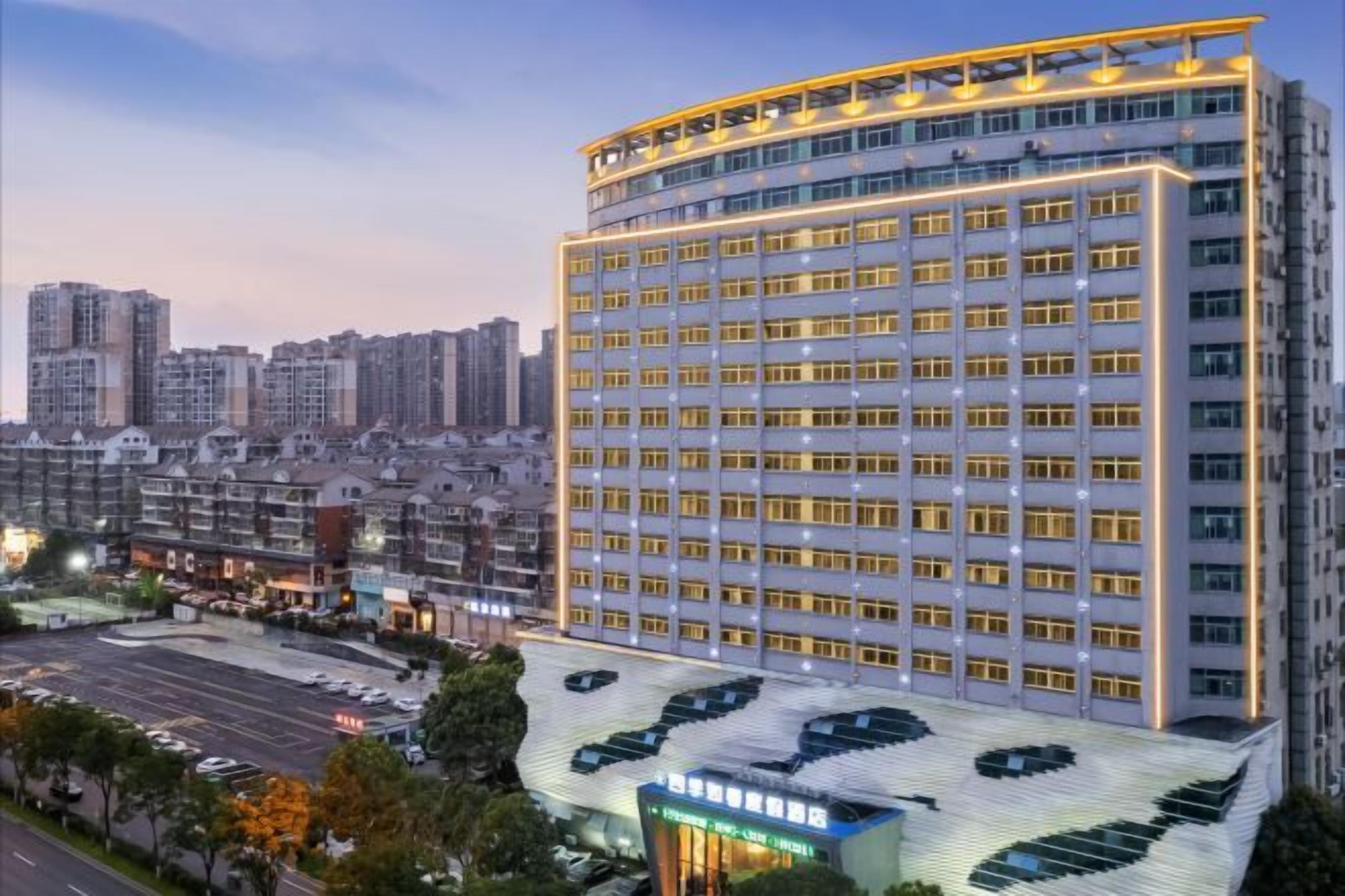 A multi-story hotel with a modern design, featuring a large number of windows and a distinctive roof structure.