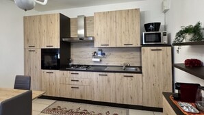 Una cocina moderna con armarios de madera, microondas y una lámpara de araña.