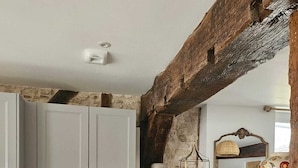 A kitchen with wooden cabinets, a stainless steel dishwasher, and a wooden countertop.