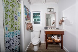 Ein Badezimmer mit Toilette, Waschbecken und Spiegel.