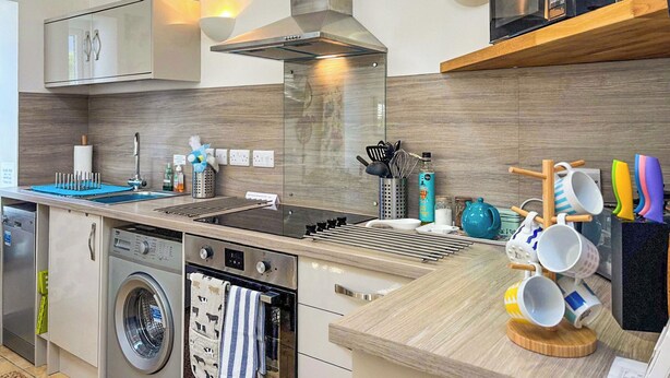 A modern kitchen with a built-in oven, microwave, and stainless steel range hood. - 1 bedroom accommodation in East Cowton (East Cowton)
