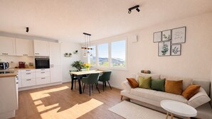 En moderne lejlighed med køkken, spiseområde og opholdsstue.