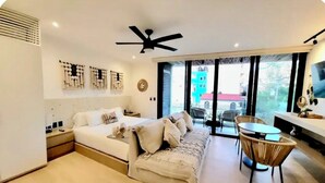 Une chambre moderne avec un lit, une table de chevet et une vue sur l’extérieur.
