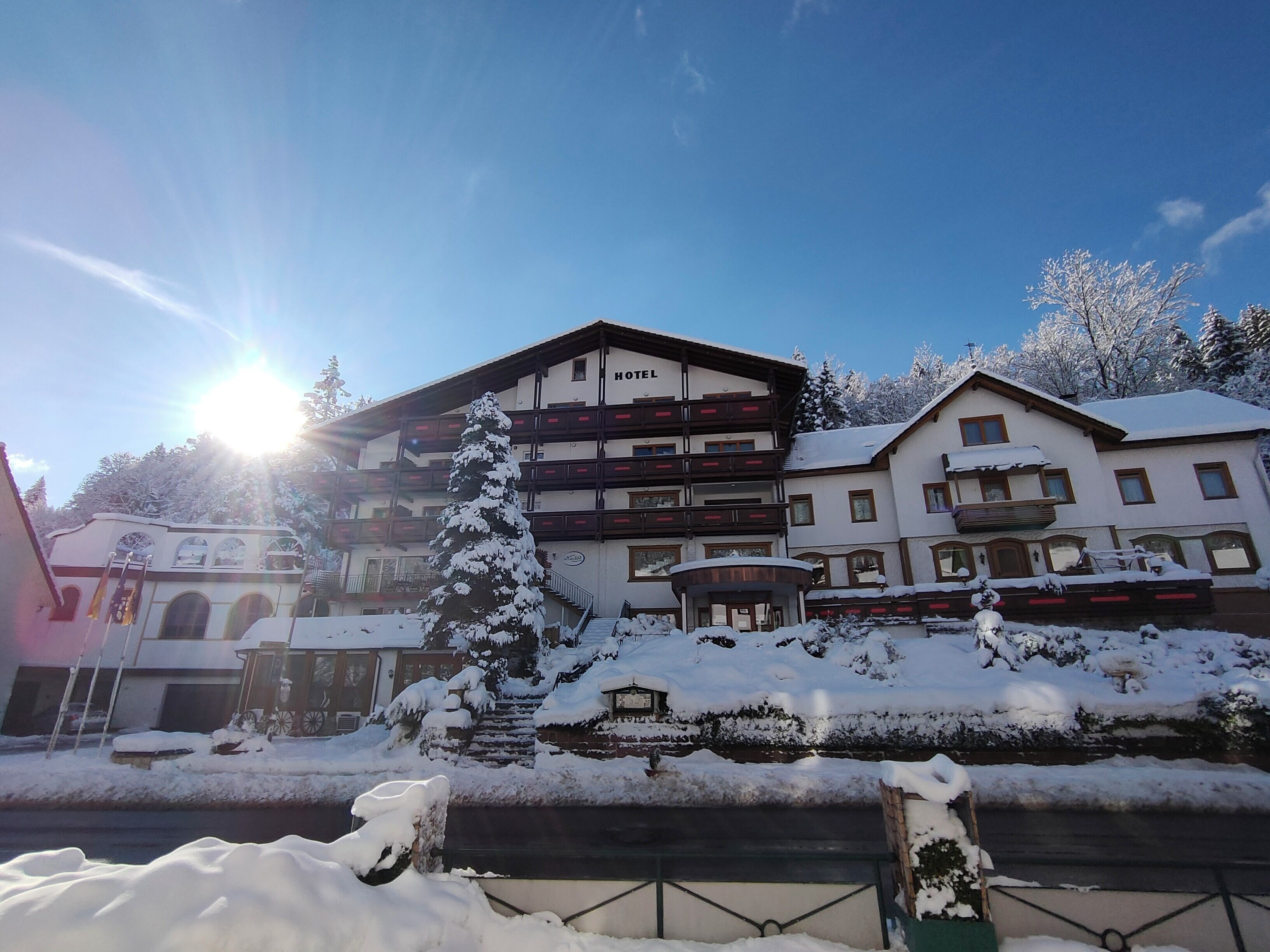 Un hotel de varios pisos, con balcones y un paisaje cubierto de nieve.