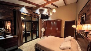 A bedroom with a large bed, wooden wardrobe, and a sliding glass door leading to a balcony. - Seasonal House (Santa Cruz de la Sierra)