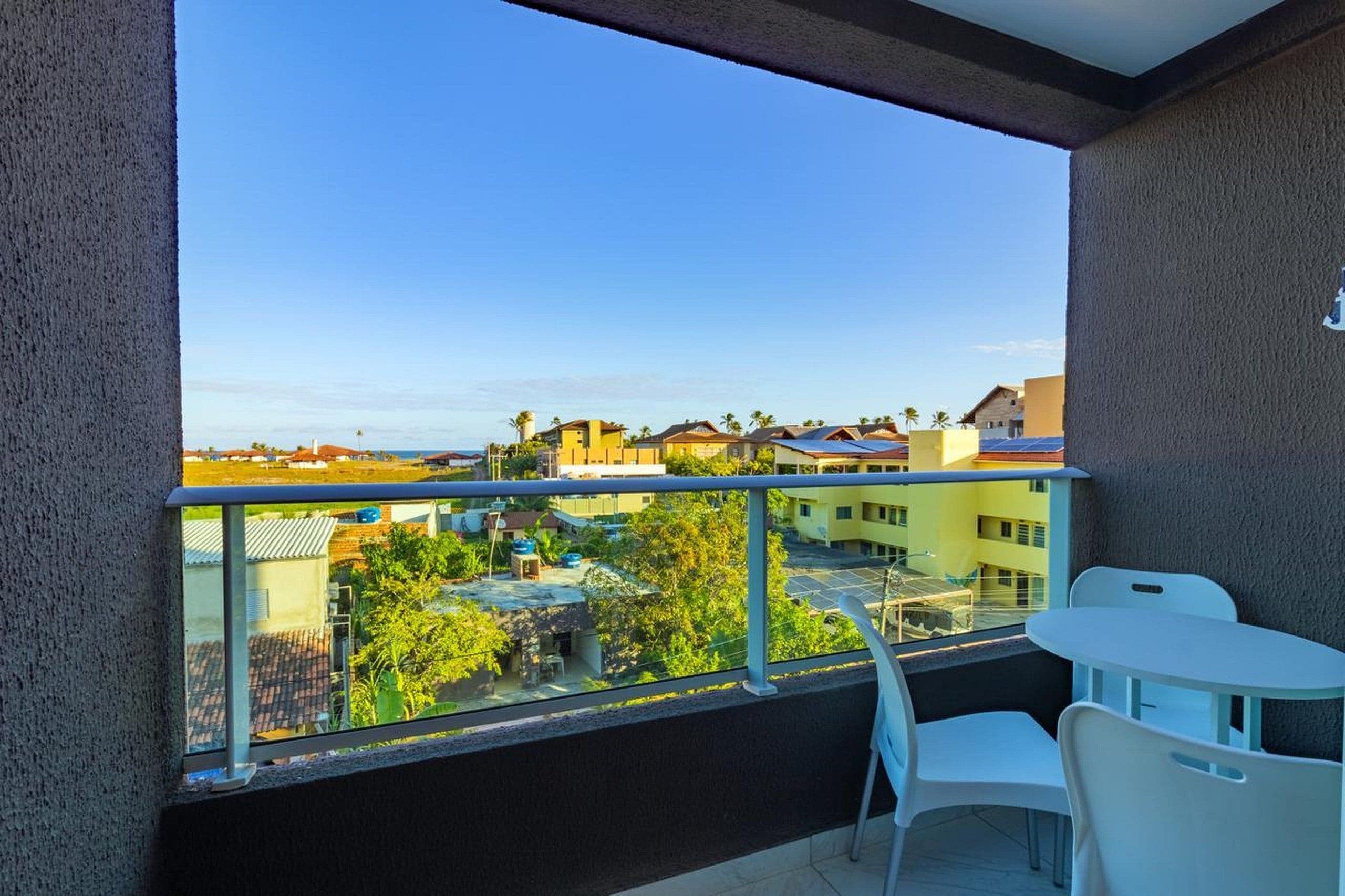 Un balcone con una vista libera su una zona residenziale, con un tavolo e sedie.