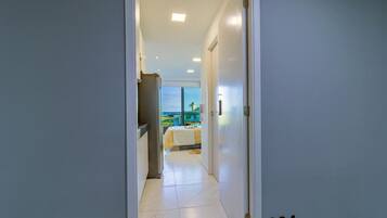 A hallway leading to a bedroom with a view of the outdoors.