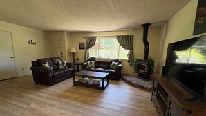 A living room with a fireplace, two sofas, a coffee table, and a television. - Bigfoot Lodge Yosemite Bass Lake (Oakhurst)