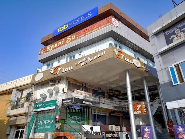 A building with multiple signs, including 'FabHotels', 'Raapi Sa', and 'Rooms & Restaurant'. - Hotel 24x7 Inn (Jalandhar)