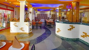 A hotel lobby with a central reception desk, multiple dining areas, and a modern design with a curved ceiling. - Hotel 24x7 Inn (Jalandhar)