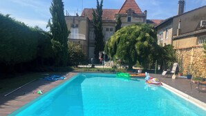 Una piscina rectangular con agua cristalina, rodeada por una terraza de madera.