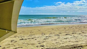 A beach with footprints in the sand and a clear view of the ocean.