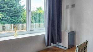A room with a window, a radiator, a wooden table, and a curtain. - 1 bedroom accommodation in Walcott (Walcott)