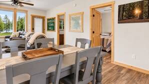 A dining area with a wooden table, grey chairs, and a wooden tray.