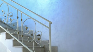 A staircase with ornate metal railings and a wooden floor.