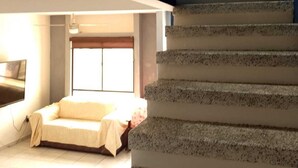 A staircase leading to a bedroom with a bed and a window.