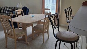 A dining area with a table and chairs, a sofa, and a window with blinds. - Sandpiper Bay 3rd Floor. 4 mi to beach. 3 bd, 2 ba, new kitchen,  pool & more (Sunset Beach)