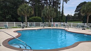 A swimming pool with a white fence, lounge chairs, and palm trees in the background. - Sandpiper Bay 3rd Floor. 4 mi to beach. 3 bd, 2 ba, new kitchen,  pool & more (Sunset Beach)