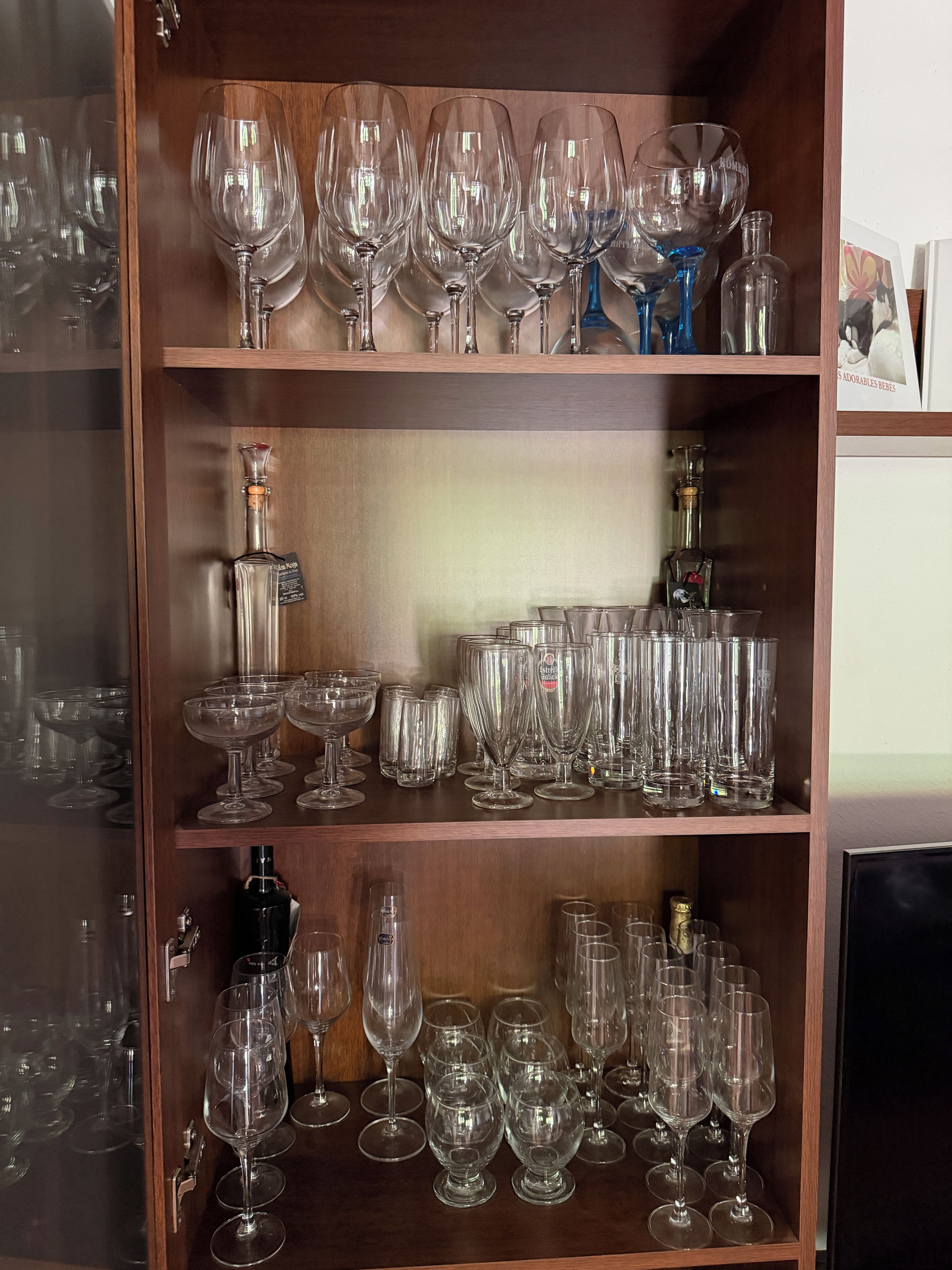 Un porte-bouteilles en bois contenant différents types de verres à vin et de bouteilles.