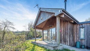 A wooden cabin with a covered porch, large windows, and a chimney. - 1 bedroom accommodation in Llandeilo (Llandeilo)