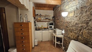 A compact kitchen with wooden cabinets, a microwave, and a small table. - Apartment central near Herbstmesse & Baloise Session (Basel)