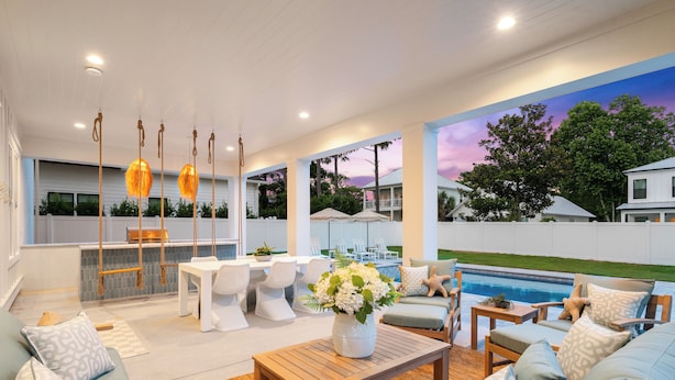 A modern outdoor living area with a pool, white furniture, and a sunset mural. - Luxe Beach Retreat Walk to Beach Pool Spa, Golf Cart, Game Room & Putting Green (Santa Rosa Beach)