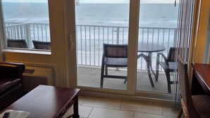 A room with a view of the ocean, a sliding glass door, a table, and two chairs. - Gorgeous Views/Beautiful Oceanfront Condo, Beach, Pool/Hot Tub, 4th Fl, 2-Bath (Daytona Beach)