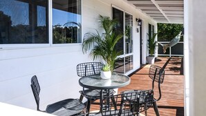 An outdoor patio with a round table and chairs, a potted plant, and a hammock. - Lake Cove Daylesford (Daylesford)