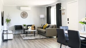 A modern living room with a sofa, two chairs, a coffee table, and a side table. - Lake Cove Daylesford (Daylesford)