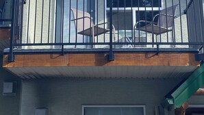 Ein zweistöckiges Haus mit Balkon, großen Fenstern und einem begrünten Dach.