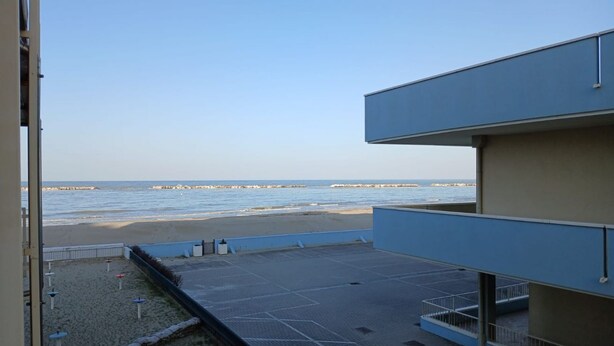 En balkon med udsigt til stranden og havet.