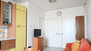 Un espacio habitable compacto con comedor, kitchenette y sofá.