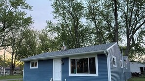 A single-story house with a front porch, a chimney, and a garage. - Beautifully remodeled house that sleeps 10 by Lake Erie Fun. (Sandusky)