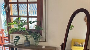 Une pièce avec un bureau en bois, un miroir et un tapis rouge.