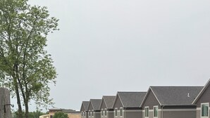 Zona residencial con casas, césped y mobiliario exterior.