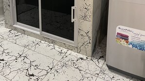 A kitchen with a marble countertop, two black bowls, a sink, and a refrigerator with a safety lock sticker. - Modern 1-bedroom apartment with AC, WiFi and Kitchen in beautiful Negril . (Negril)