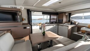 Interior moderno de autocaravana con comedor, cocina y asientos.