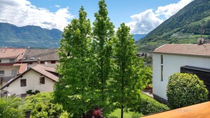 A residential area with houses, a large tree, and mountains in the background. - Apartment 'Hofanger Tirol' with Mountain View, Balcony and Wi-Fi (Algund)