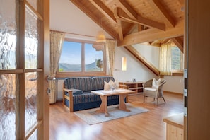 Une pièce avec un plafond en bois, un canapé, une table et une chaise.
