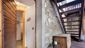 A rustic interior with a wooden door, stone wall, and a small wooden stool. - Studio 'Landa' with Balcony and Wi-Fi (Aosta)