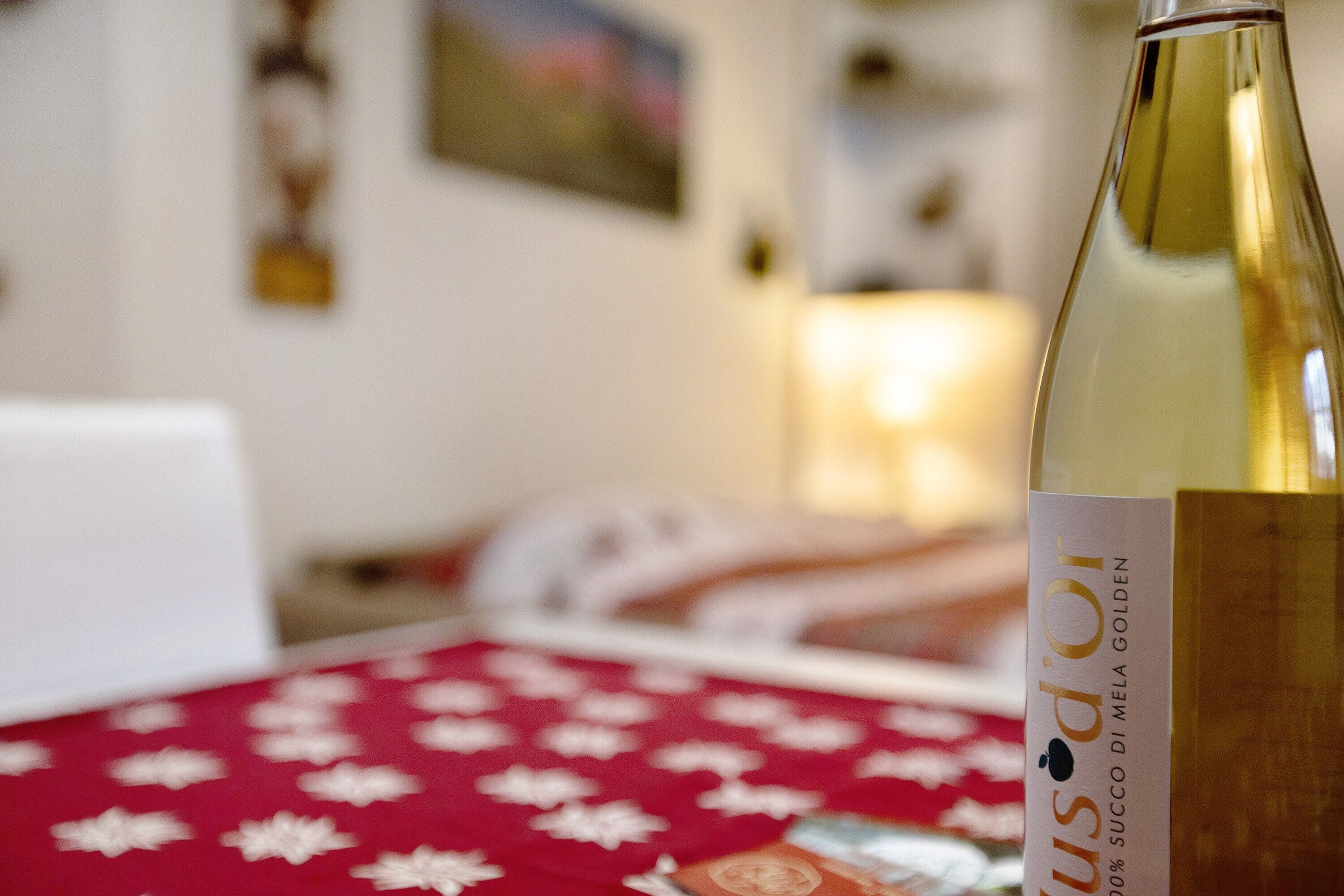 Une bouteille de vin sur une table recouverte d’une nappe rouge.