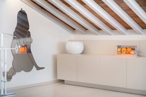 A modern interior with a white cabinet, a white vase, and a wall-mounted abstract sculpture. - Apartment 'Luxury Rooftop Verona' with Wi-Fi and Air Conditioning (Verona)