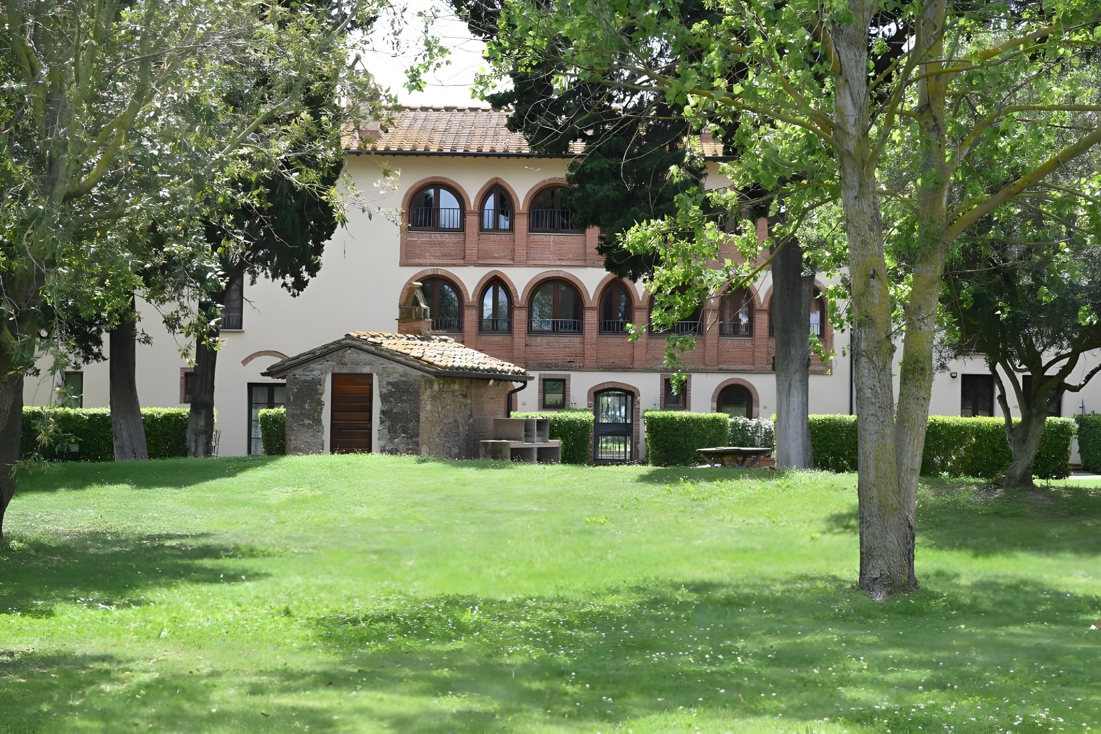 Un edificio con un cortile interno, finestre ad arco e un tetto in tegole.