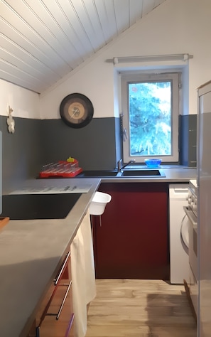 A compact kitchen with a window, a clock, and a sink. - Holiday Home "La Cardabelle" – Nature Retreat in Bonac-Irazein, Private Garden, Mountain Views (Bonac-Irazein)