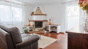 A living room with a fireplace, leather sofa, wooden coffee table, and a vase with flowers. - Holiday Home 'Ohana' with Sea View, Wi-Fi and Air Conditioning (Carini)
