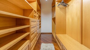 A walk-in closet with wooden shelves, drawers, and hanging space. - Holiday Home 'Ohana' with Sea View, Wi-Fi and Air Conditioning (Carini)
