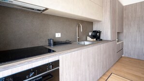 Une cuisine moderne équipée d’une cuisinière intégrée, d’une machine à café et d’un évier.
