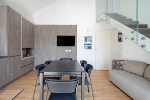 Una cucina moderna con zona pranzo, divano e una scala.